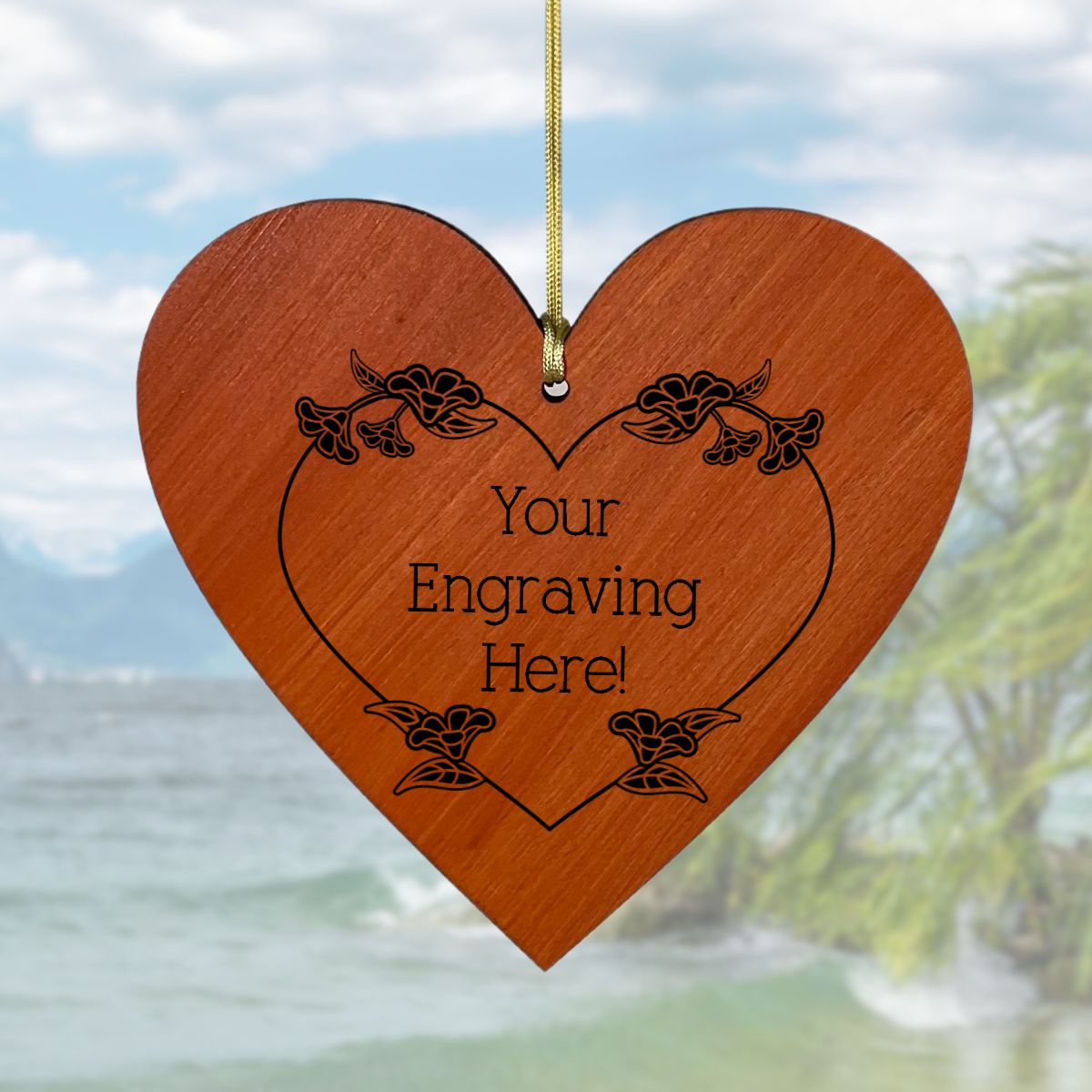 Wooden heart-shaped ornament with engraved text against a blurred natural background
