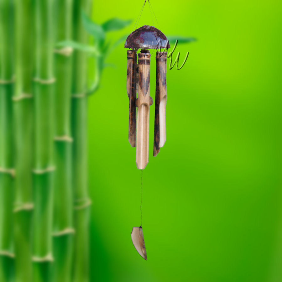 Bamboo wind chime with a half coconut as the top and a V-shape design on the tubes hanging against a green bamboo background