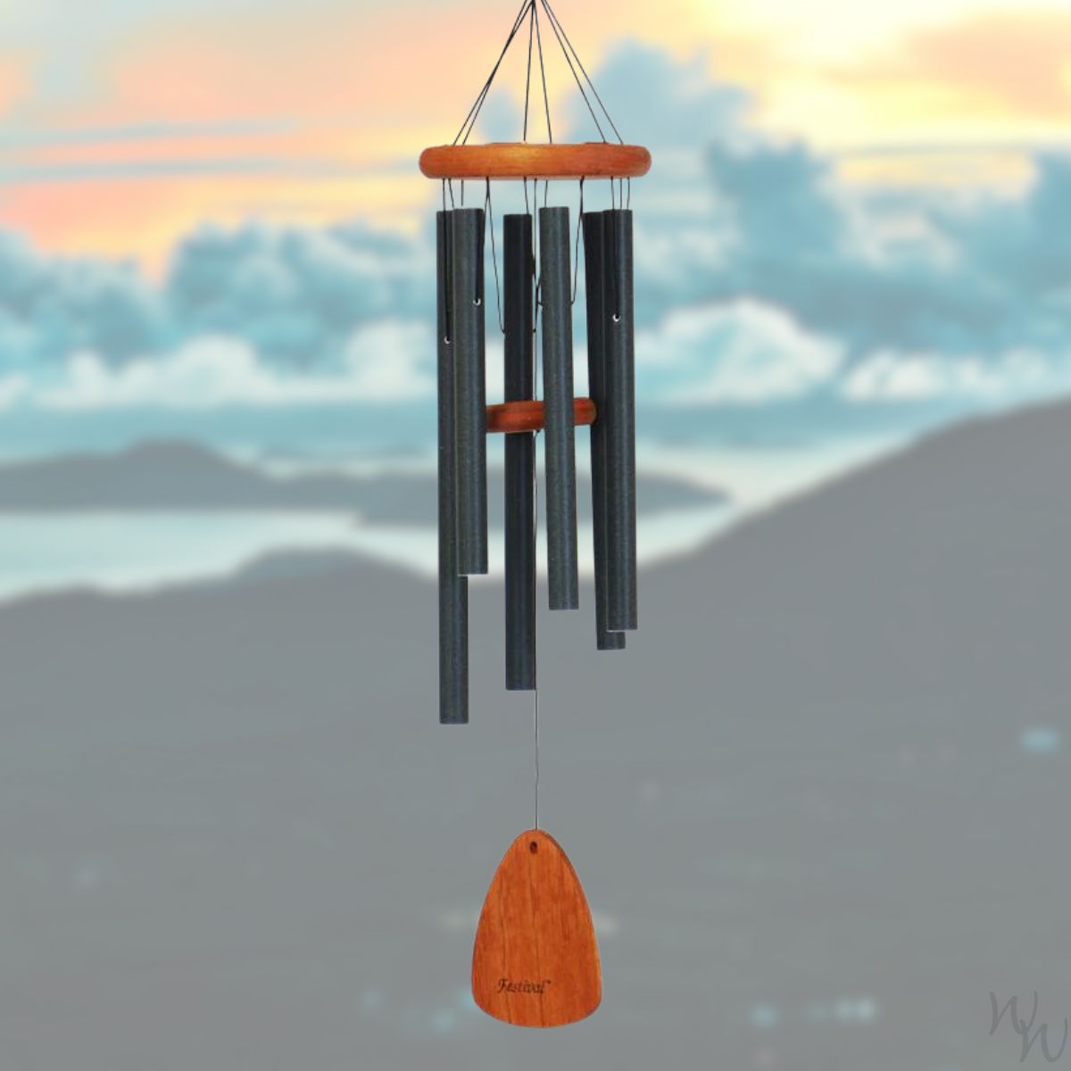Festival 30 inch forest green wind chime with wooden striker and wind sail, against a scenic background of mountains and sunset.