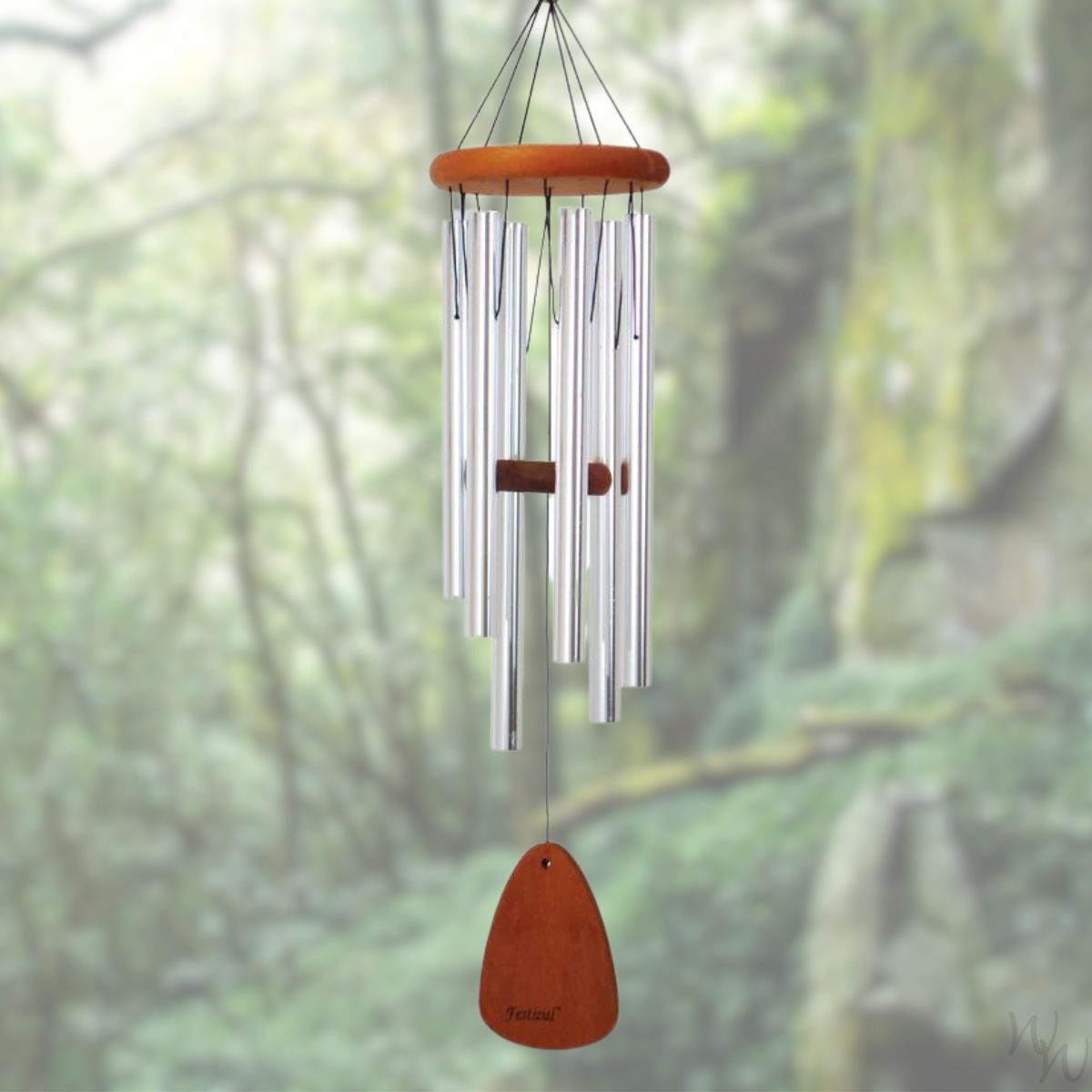 Festival 30 inch silver wind chime with wooden striker and wind sail,  against a blurred natural background