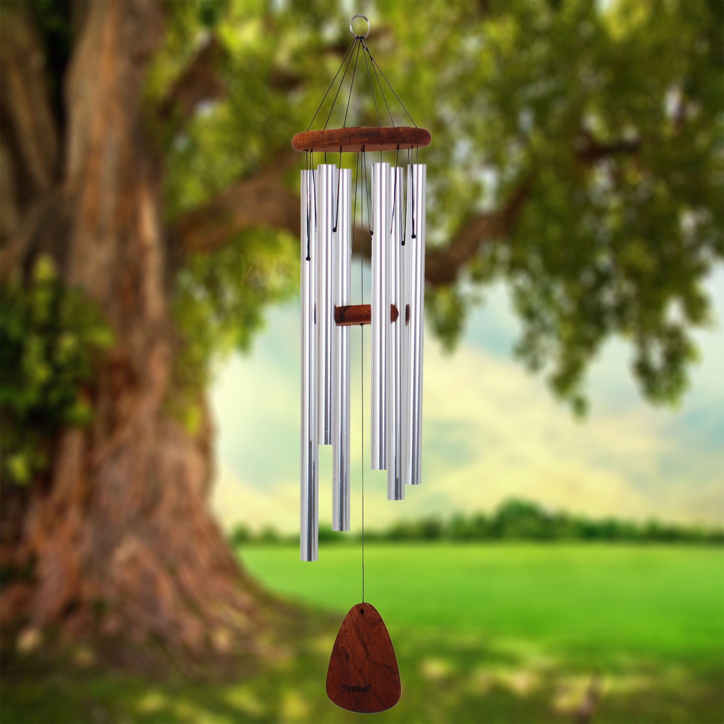 Festival 36 inch silver wind chime with wooden striker and wind sail, hanging from a tree with a natural background