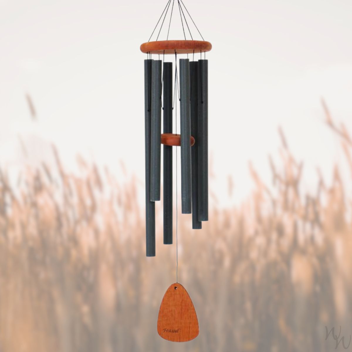 Festival 42 inch forest green wind chime with wooden accents against a blurred natural background