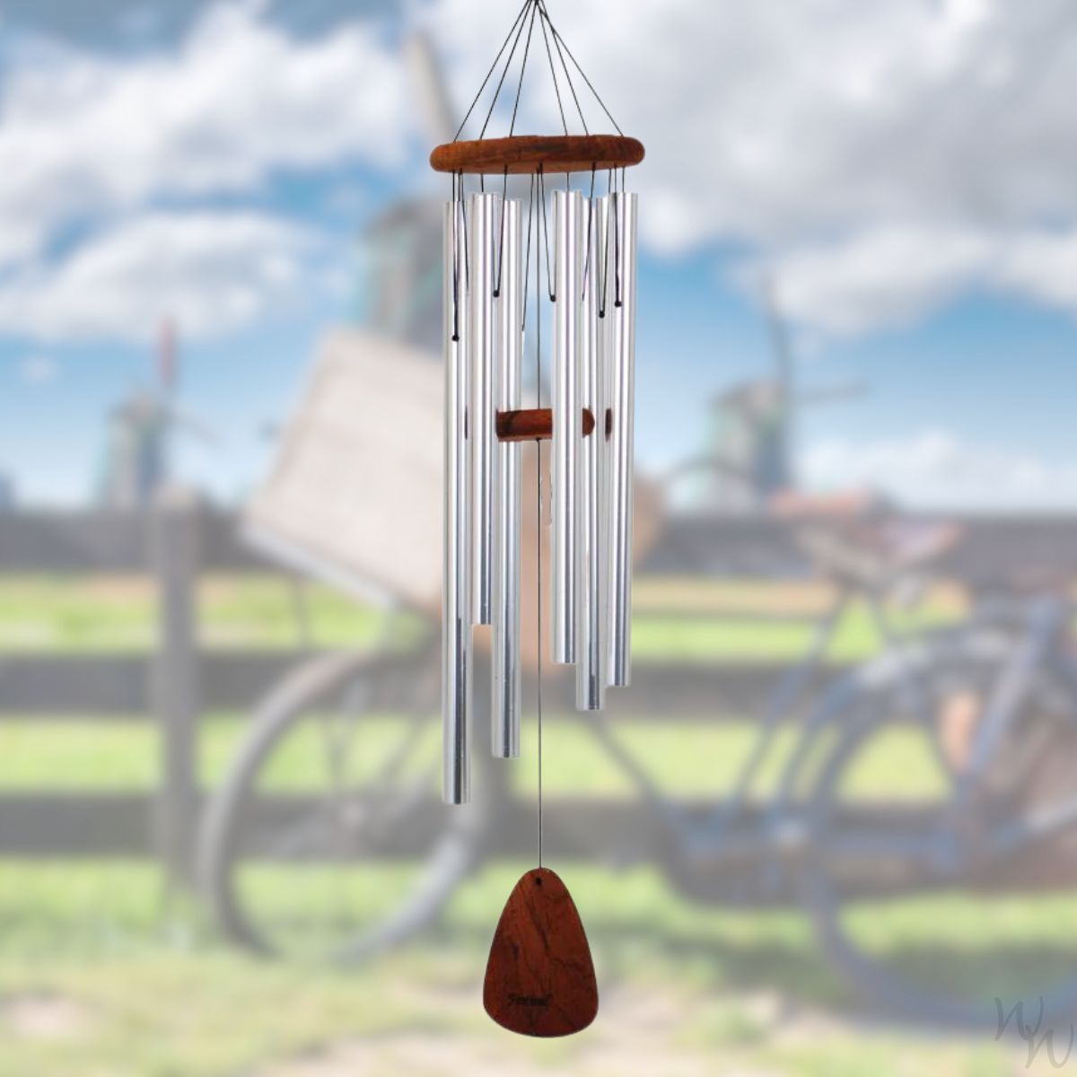 Festival 42 inch silver wind chime with wooden accents against a blurred outdoor background