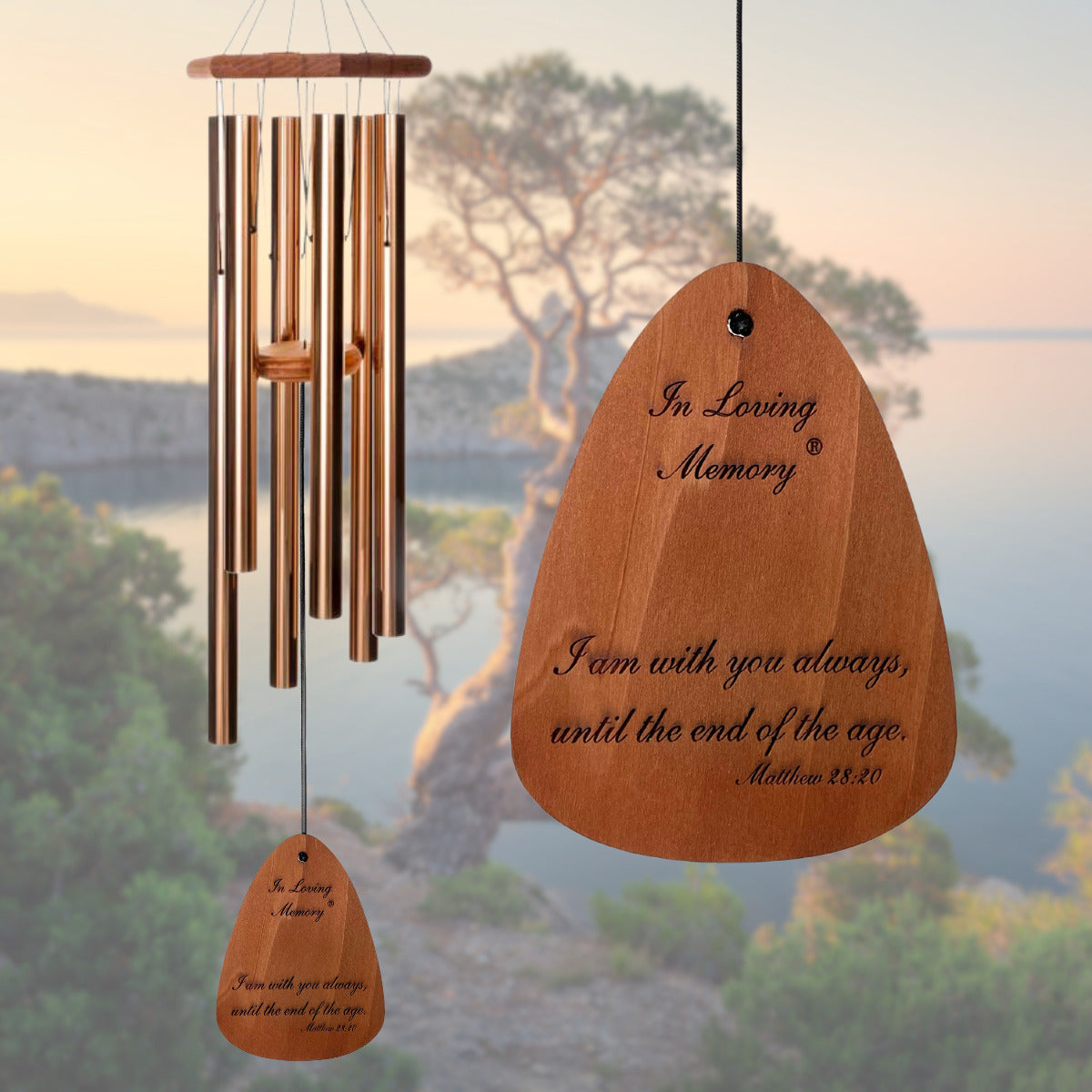 In Loving Memory 42 inch bronze wind chime with "I am with you always until the end of the age Matthew 28:20" pre-engraved on one side of the wind sail. The blurred background is a tree on a river's edge.