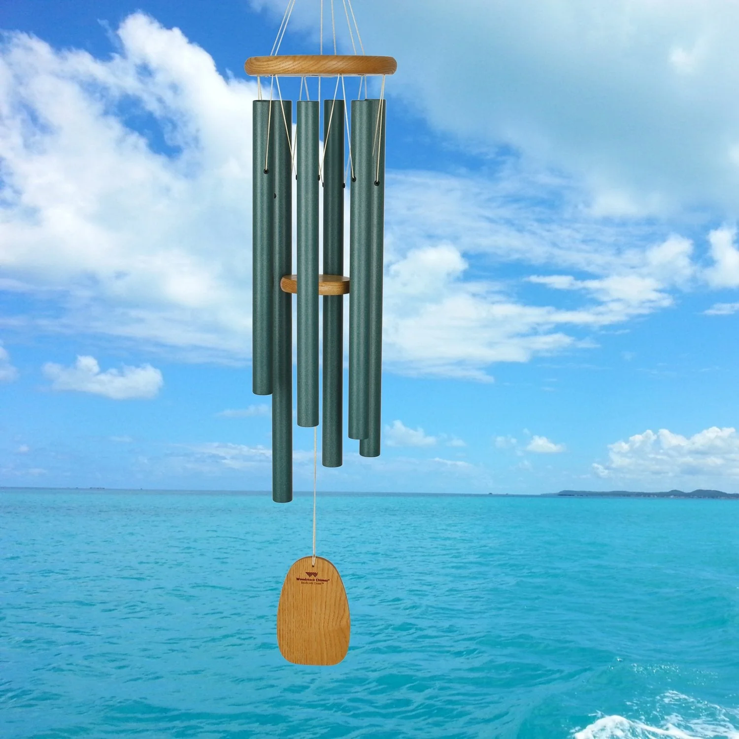 Woodstock Seascapes wind chime in size Large, 37 inches, green tubes, with wooden accents on a background of a blue sky with clouds and ocean.