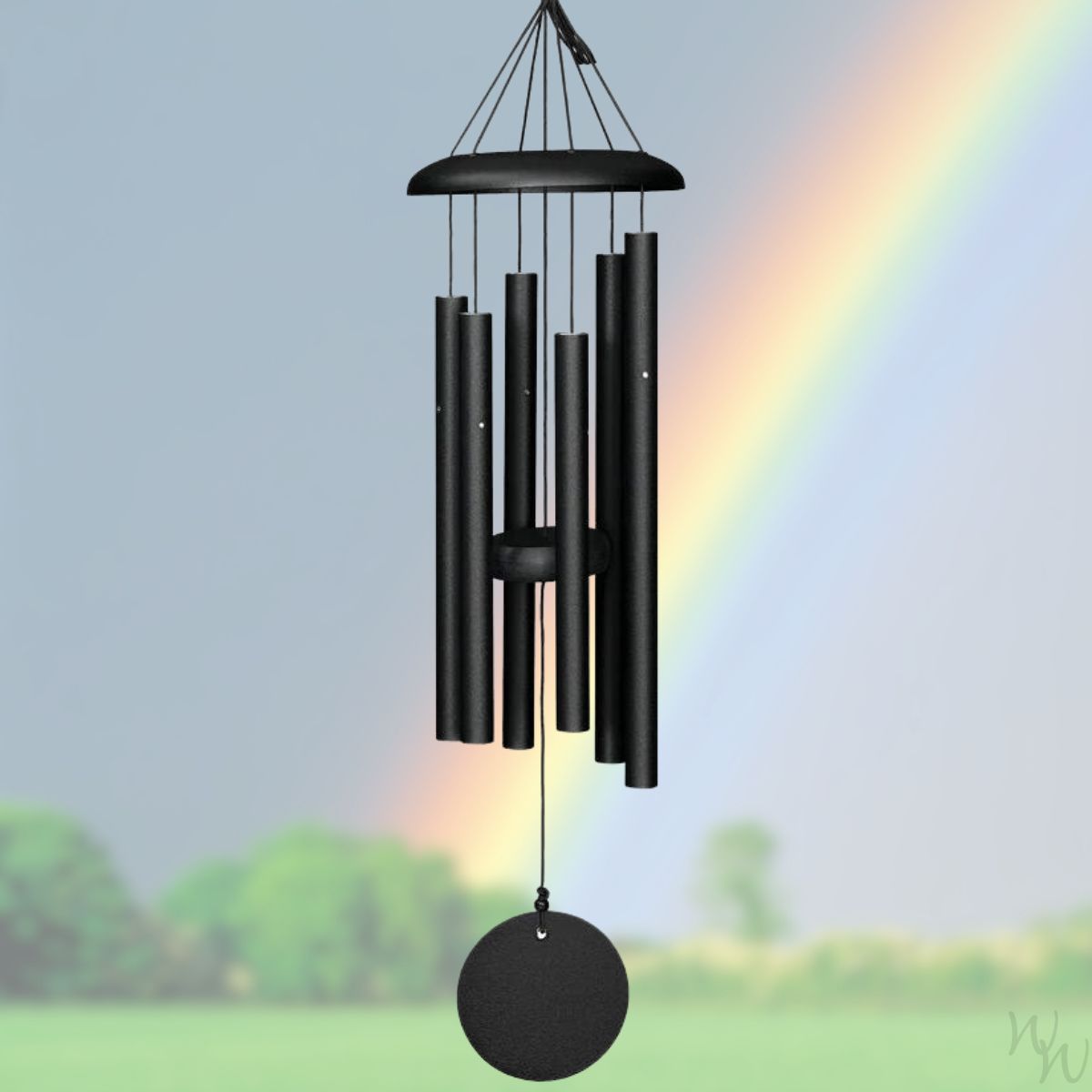 Black Corinthian Bells 27 inch wind chime against a scenic background with a rainbow