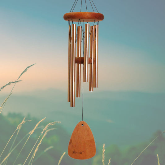 Festival 24 inch bronze wind chime with wooden striker and wind sail, with a blurred natural background