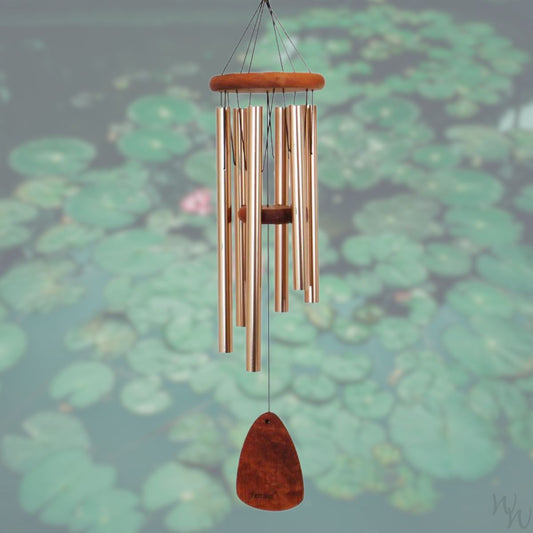 Festival 30 inch bronze wind chime with wooden striker and wind sail,  against a blurred natural background