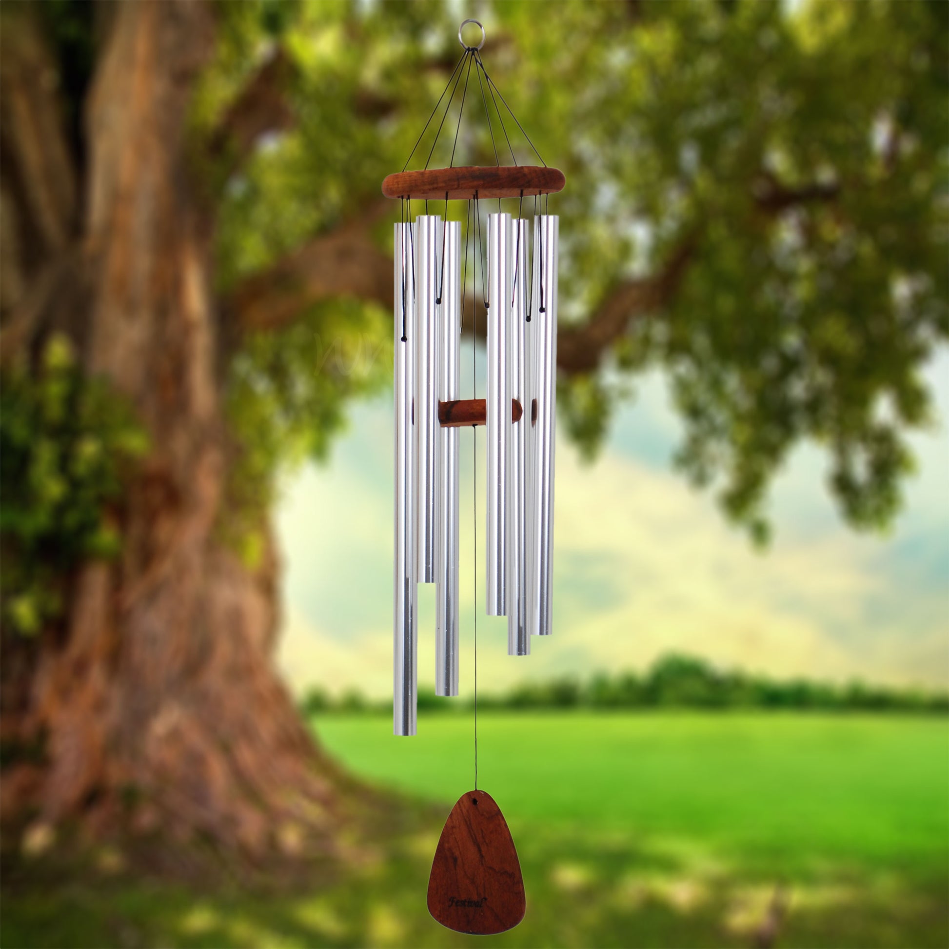 Festival 36 inch silver wind chime with wooden striker and wind sail, hanging from a tree with a natural background