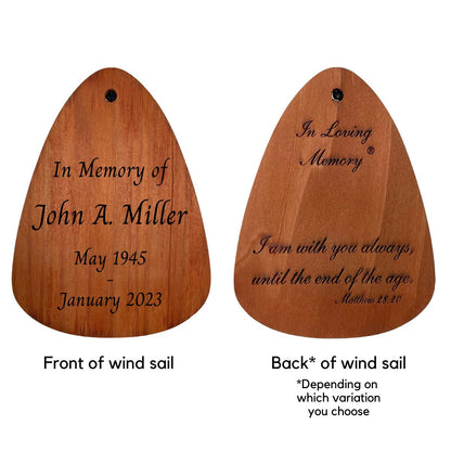 Example engraving on front and back of a wooden 'IN LOVING MEMORY' BRAND wind sail for memorial wind chimes, featuring custom text ‘In Memory of John A. Miller, May 1945 – January 2023’ on the front, and Bible verse ‘I am with you always, until the end of the age. – Matthew 28:20’ on the back with ‘In Loving Memory’ heading; shape is teardrop-style in warm natural wood finish