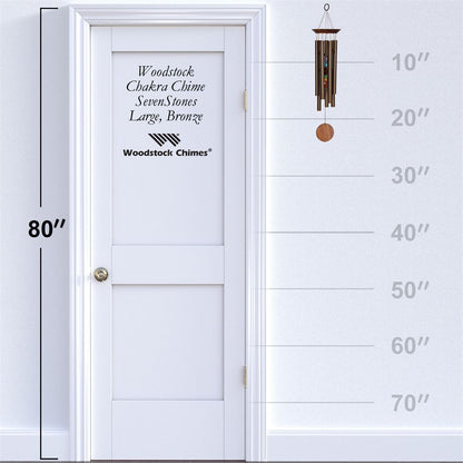Woodstock Chimes CHAKRA BRONZE WIND Chime displayed on a white door with height measurement scale